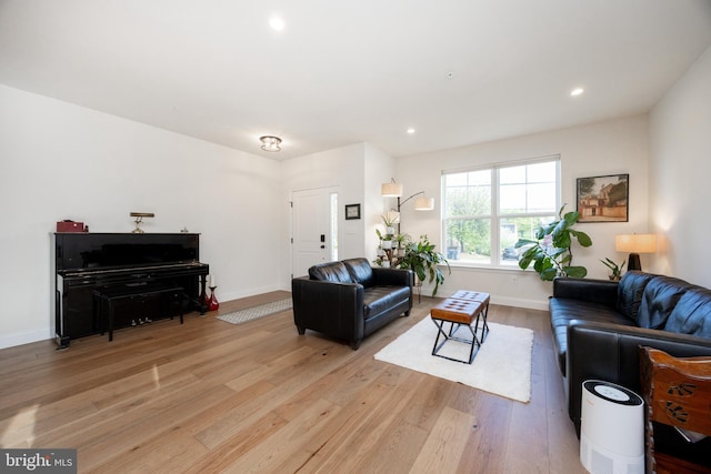 living room with baseboards, recessed lighting, and light wood finished floors
