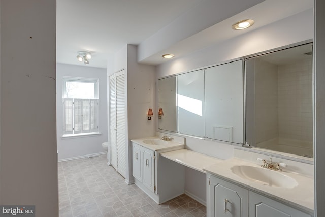 full bathroom featuring toilet, baseboards, and vanity