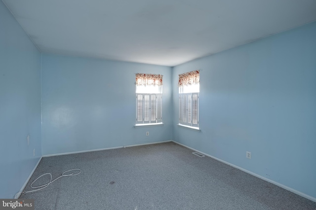 empty room featuring baseboards, carpet, and visible vents