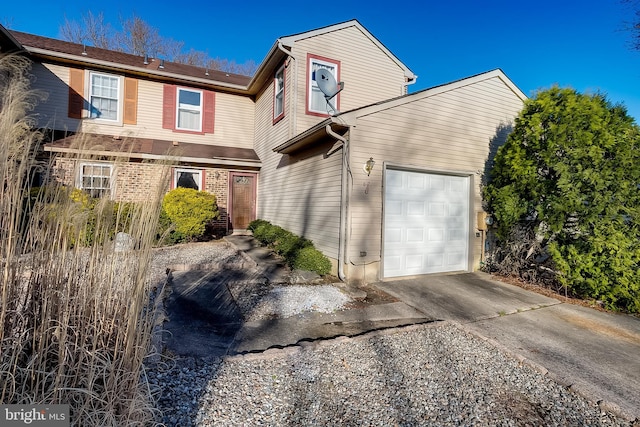 traditional-style home featuring a garage and driveway