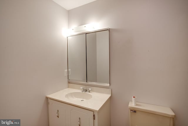 half bathroom featuring vanity and toilet