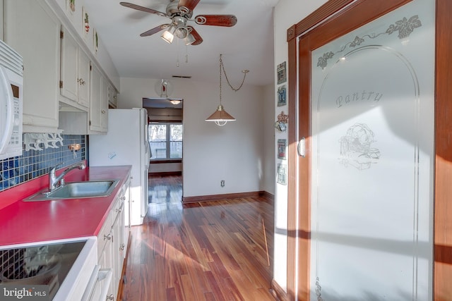 kitchen with white cabinets, ceiling fan, a sink, white appliances, and wood finished floors