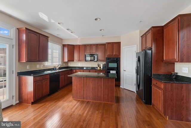 136 Martha Lewis Blvd, Havre De Grace, MD 21078 - kitchen featuring wood-type flooring, a center island, dark stone counters, backsplash, and black appliances
