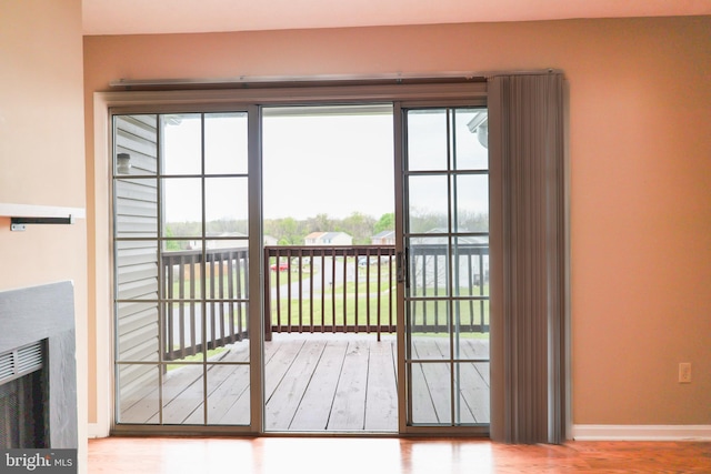 doorway with baseboards and wood finished floors