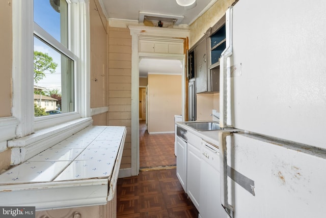 kitchen featuring white appliances, white cabinetry, ornamental molding, and a sink