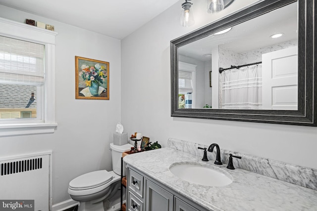 full bath with toilet, curtained shower, radiator, and vanity