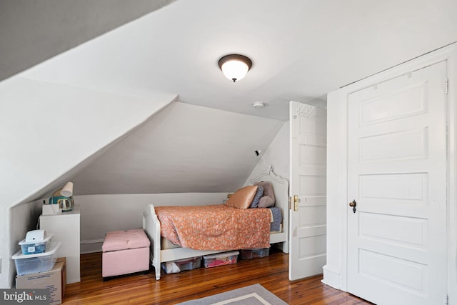 bedroom featuring lofted ceiling and wood finished floors