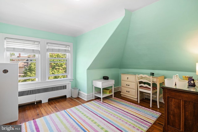bedroom featuring wood-type flooring, baseboards, lofted ceiling, and radiator