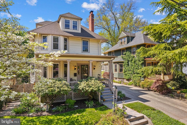 traditional style home with covered porch and a chimney