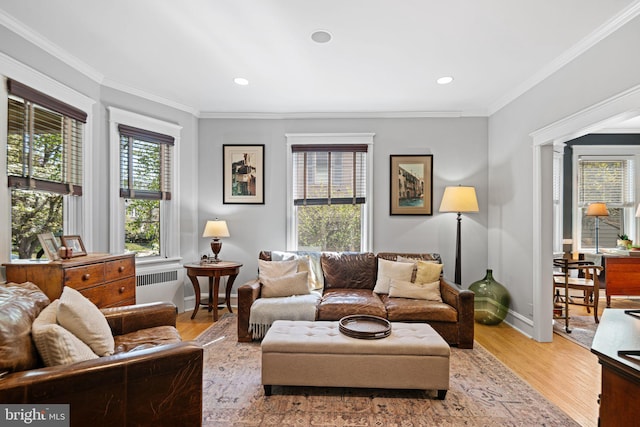 living area featuring baseboards, radiator heating unit, ornamental molding, recessed lighting, and light wood-style flooring
