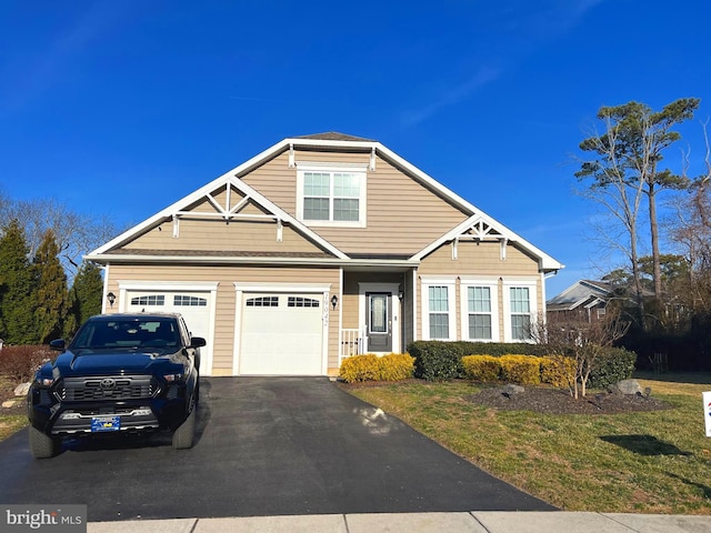 craftsman house featuring a garage, a front lawn, and aphalt driveway