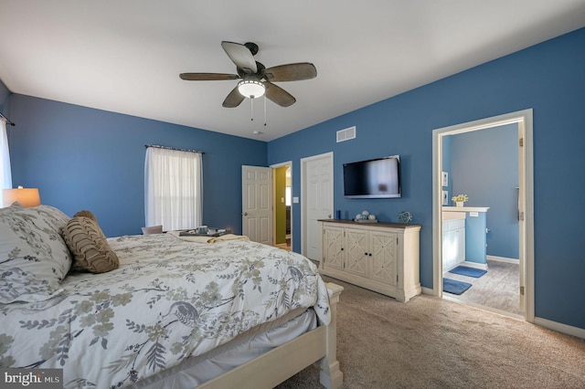 bedroom with a ceiling fan, visible vents, carpet floors, baseboards, and ensuite bathroom