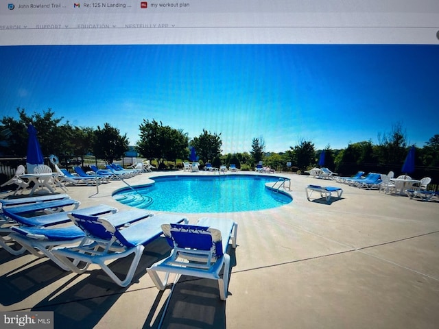 community pool featuring a patio and fence