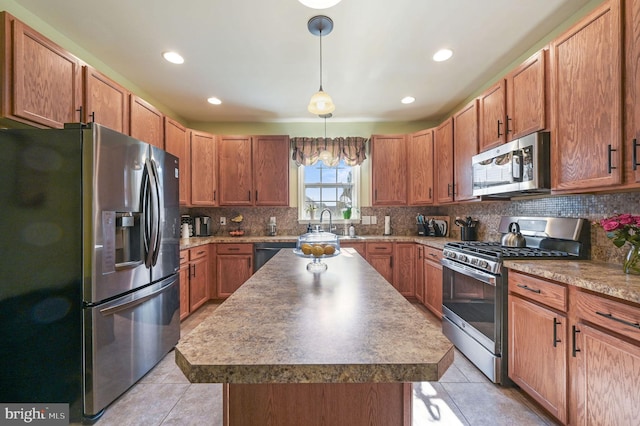 kitchen featuring stainless steel appliances, hanging light fixtures, decorative backsplash, and light tile patterned floors