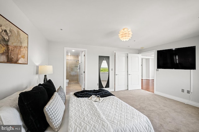 carpeted bedroom with baseboards and ensuite bath