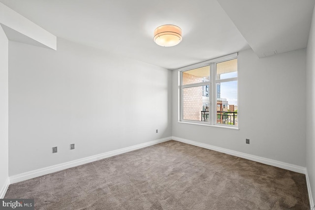 unfurnished room with baseboards and carpet flooring