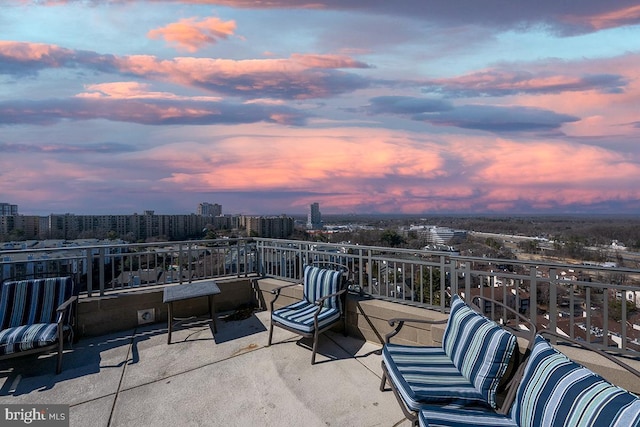 patio terrace at dusk featuring a city view