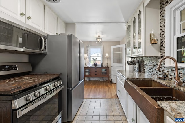 1014 Holmes Ave, Charlottesville, VA 22901 - kitchen featuring a sink, white cabinetry, light stone countertops, and stainless steel appliances
