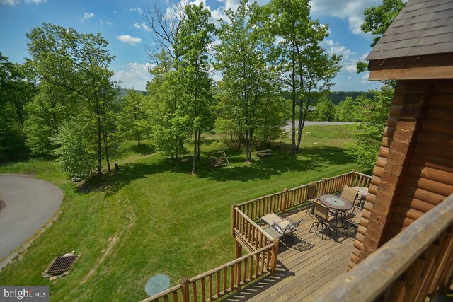 view of yard with a wooden deck and outdoor dining area