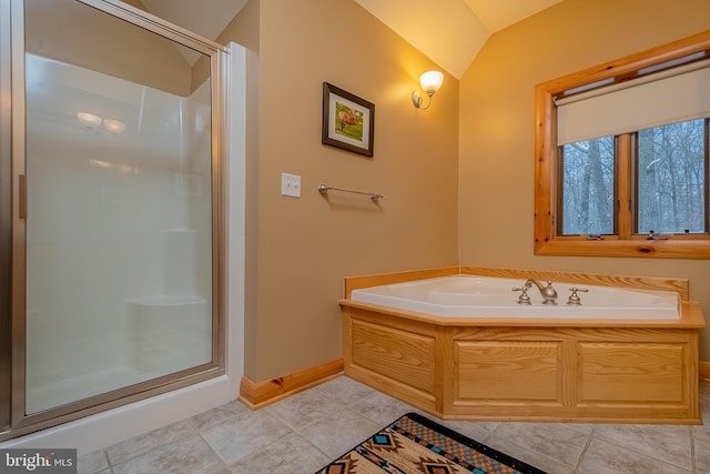 full bathroom with tile patterned flooring, baseboards, vaulted ceiling, a garden tub, and a stall shower