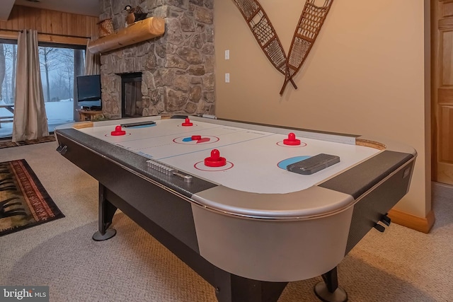 recreation room with a fireplace and carpet