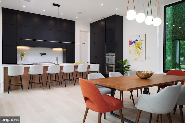 dining area with indoor wet bar, recessed lighting, and a towering ceiling