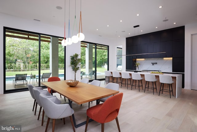 dining area featuring light wood-style floors, bar, recessed lighting, and visible vents