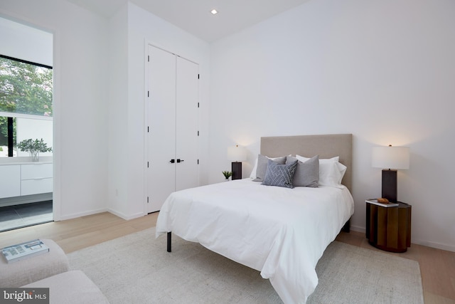bedroom with baseboards, wood finished floors, and a closet