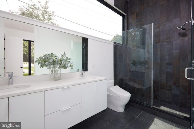 bathroom with double vanity, a stall shower, a sink, tile patterned floors, and toilet