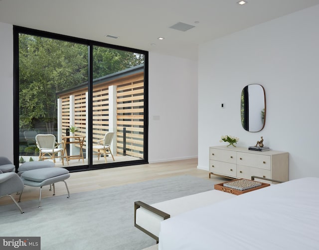 bedroom featuring recessed lighting, a wall of windows, wood finished floors, and visible vents
