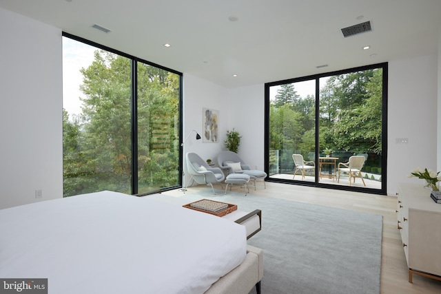 bedroom with floor to ceiling windows, multiple windows, and visible vents