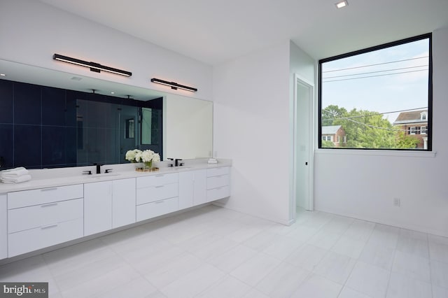 bathroom with a sink, a stall shower, and double vanity