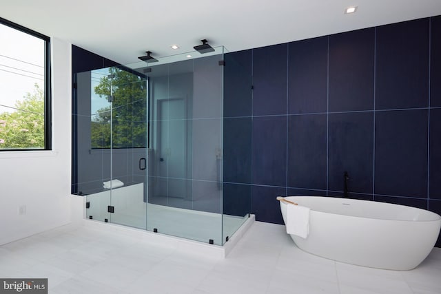full bath featuring a stall shower and a soaking tub