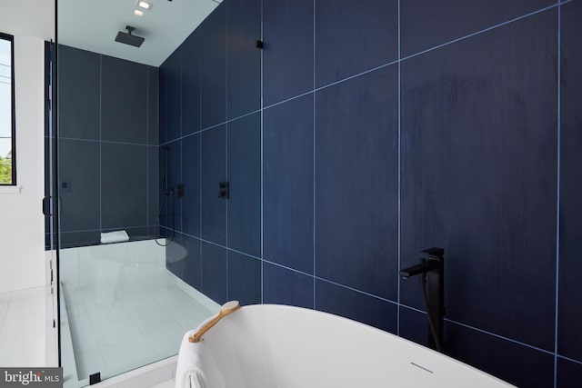 bathroom with a freestanding tub and a stall shower