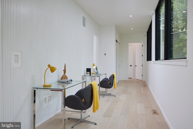 office space with visible vents, light wood-style floors, and baseboards