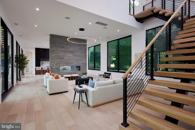 living room with stairway, plenty of natural light, and light wood-style flooring