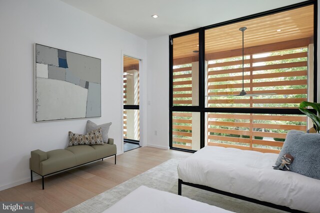bedroom with a wall of windows, baseboards, recessed lighting, and wood finished floors