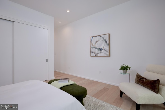 bedroom featuring light wood-style floors, recessed lighting, baseboards, and a closet