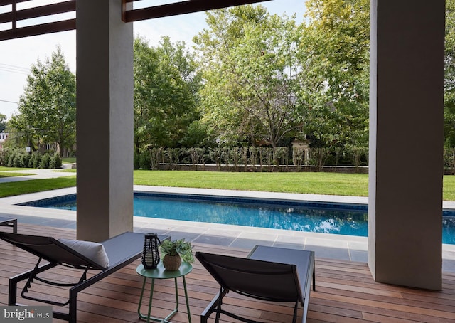 outdoor pool featuring a lawn