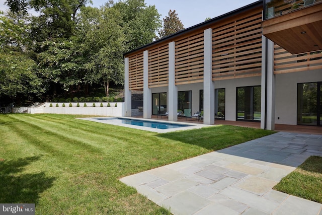 exterior space with a lawn, a fenced in pool, and a patio