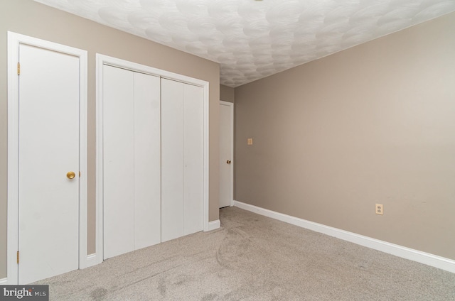 unfurnished bedroom featuring carpet, a closet, and baseboards