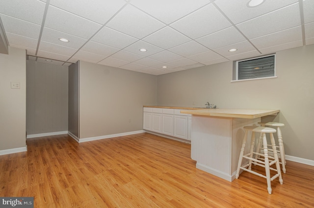 bar with a paneled ceiling, baseboards, light wood-style flooring, and recessed lighting