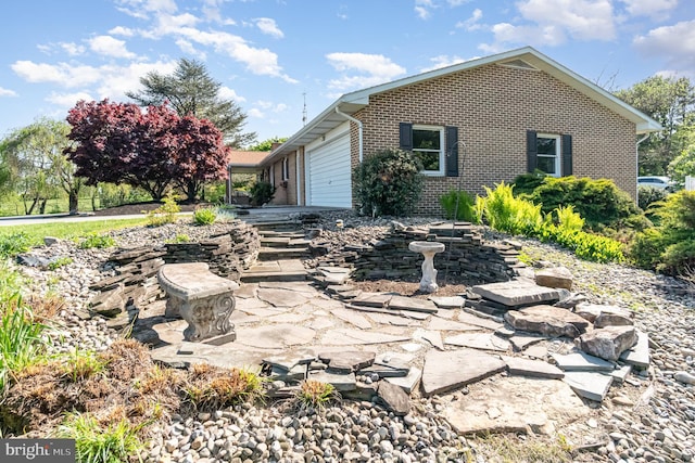 view of front of house featuring brick siding and a garage