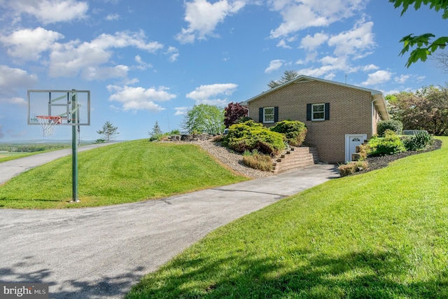 view of side of home with a yard and brick siding