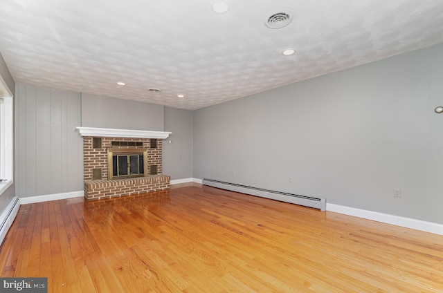unfurnished living room featuring hardwood / wood-style flooring, a baseboard heating unit, visible vents, recessed lighting, and baseboards
