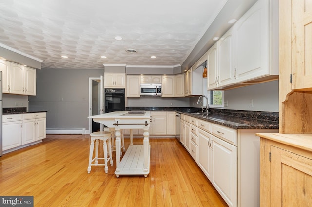 kitchen with a sink, recessed lighting, white cabinets, and appliances with stainless steel finishes