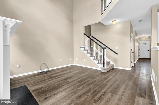 9 Ryan Ct, Telford, PA 18969 - unfurnished living room featuring baseboards, stairway, a towering ceiling, and wood finished floors