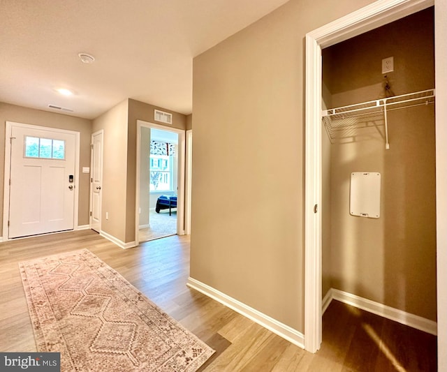 foyer with baseboards, light wood-type flooring, and visible vents