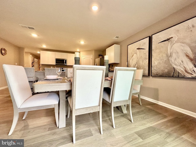 dining room featuring recessed lighting, baseboards, visible vents, and light wood-type flooring