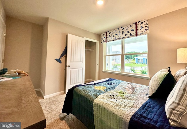 carpeted bedroom featuring baseboards and a closet